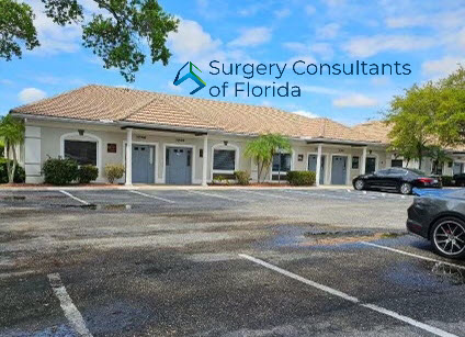 A medical facility on a sunny day in Sarasota: surgery consultants of Florida, with a tranquil parking lot and inviting entrance.