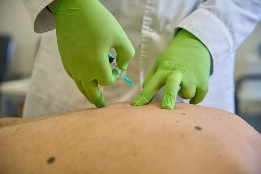 Doctor injecting a patients back