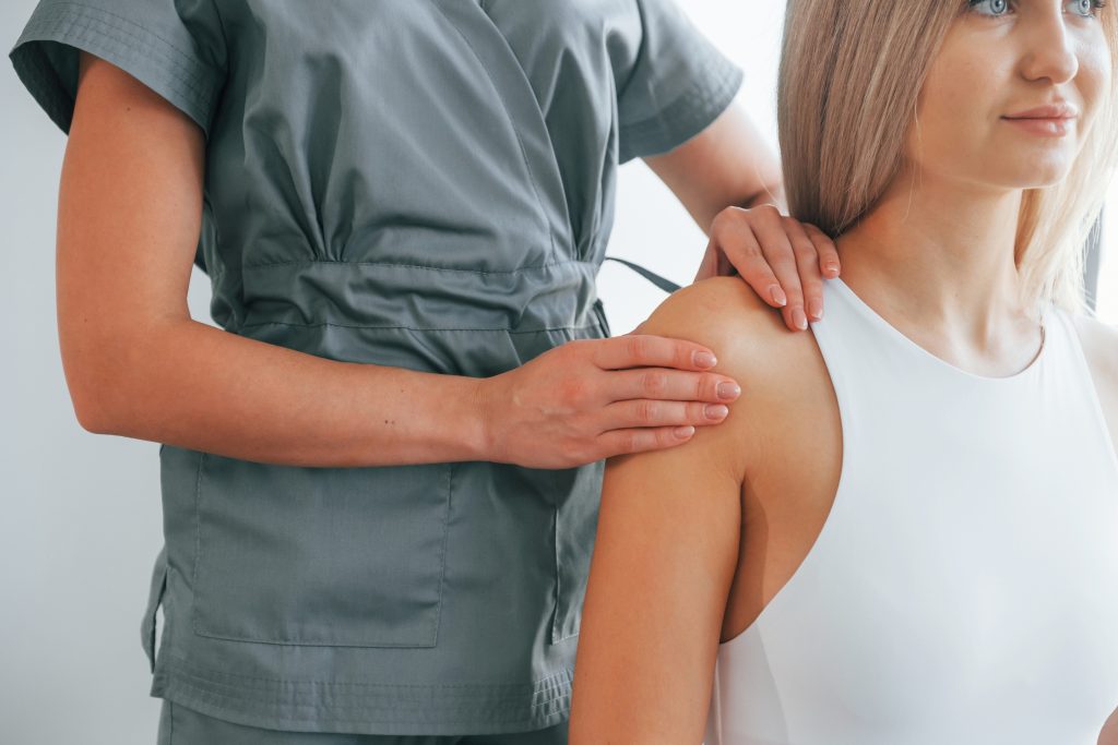 Doing massage. Woman is in health center getting help by doctor.