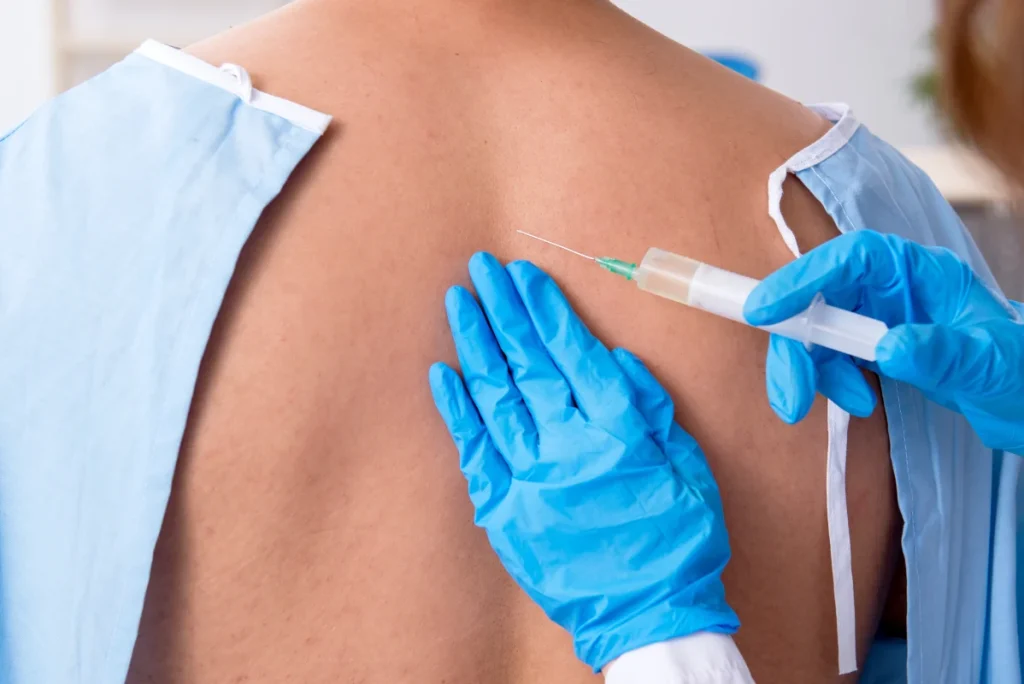 Doctor giving spinal injection for back pain treatment.